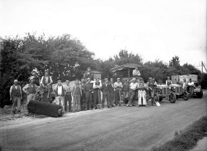 Vejarbejdssjak med traktorer, damptromler og en lastbil